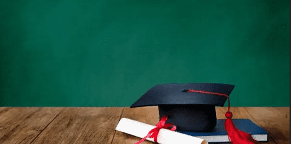 A chalkboard behind a graduation cap.