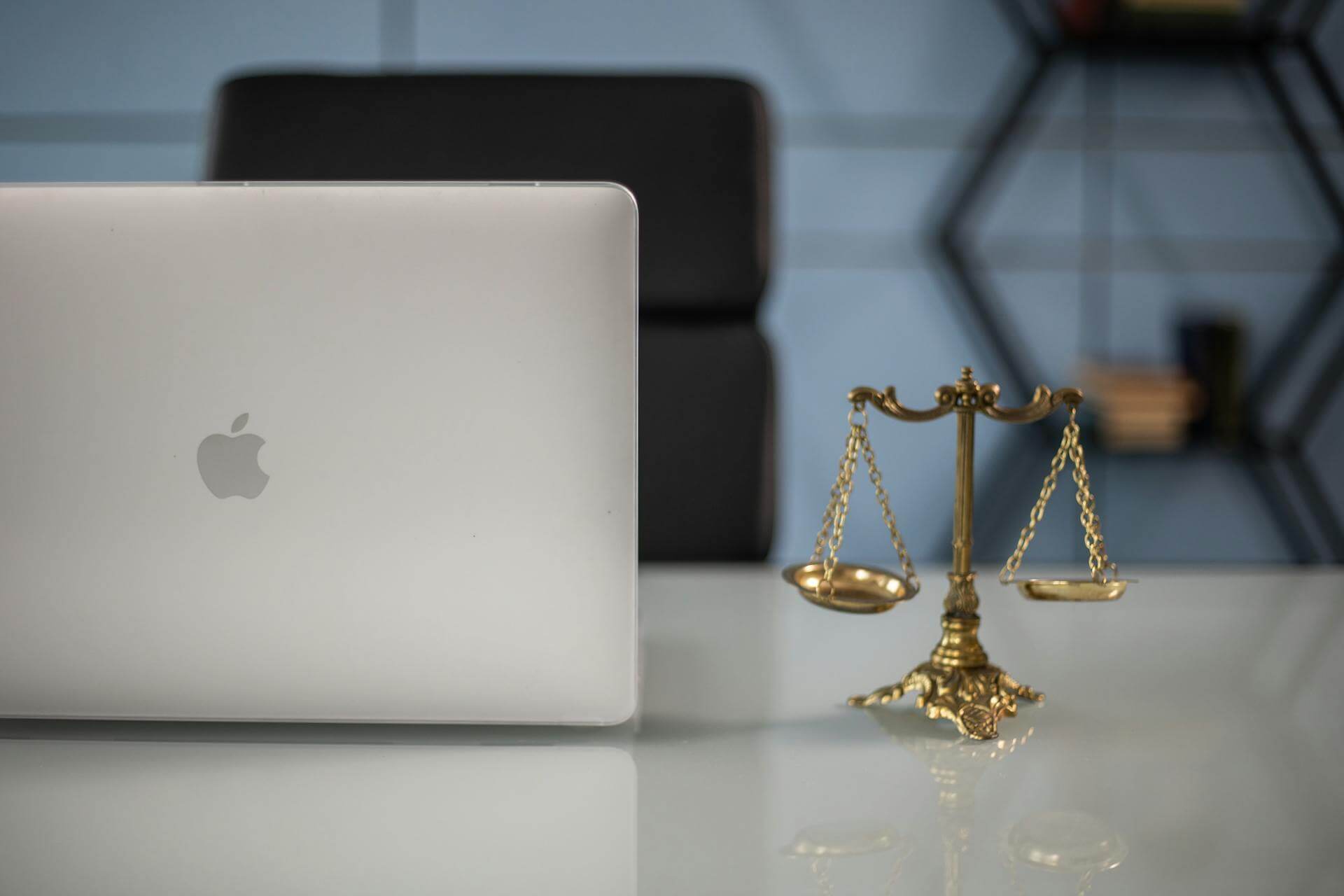 The scales of justice sitting next to a laptop.